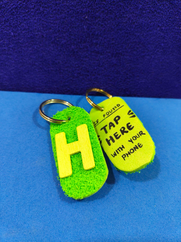Hand-painted green geo-tag with letter H, and a bright yellow-green tag reading IF FOUND TAP HERE WITH YOUR PHONE