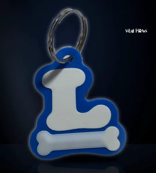 The front of the VitalPaws One Tag: a white letter L and a bone on blue