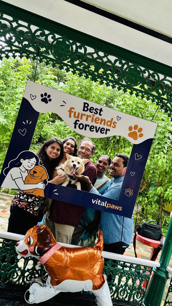 A family with their dog in the Vital Paws photo frame at Paw Paint
