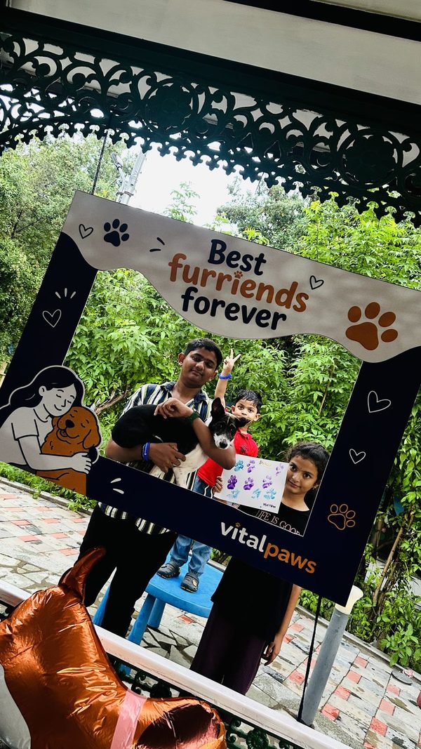 Three children with their dog and its painted paw-print card at Paw Paint