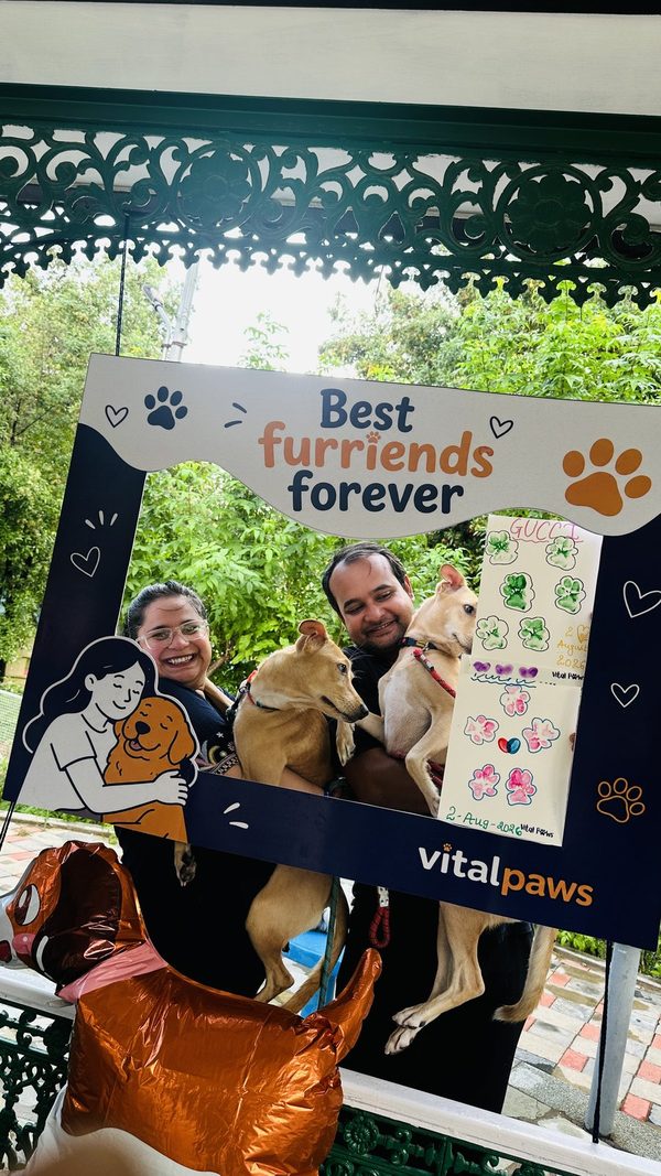 A couple with their two dogs and the dogs’ painted paw-print card at Paw Paint