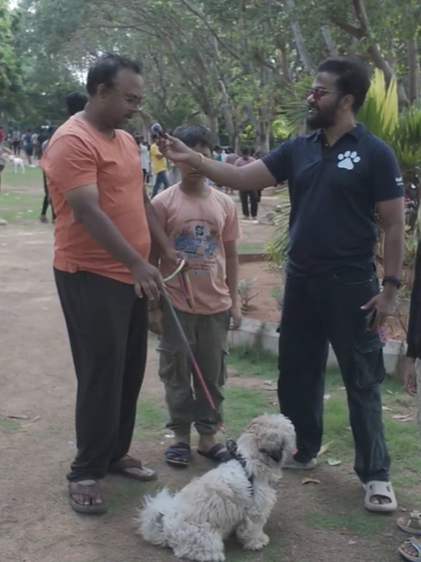 A Vital Paws team member talking with a father and son and their dog at the Reunite tag event